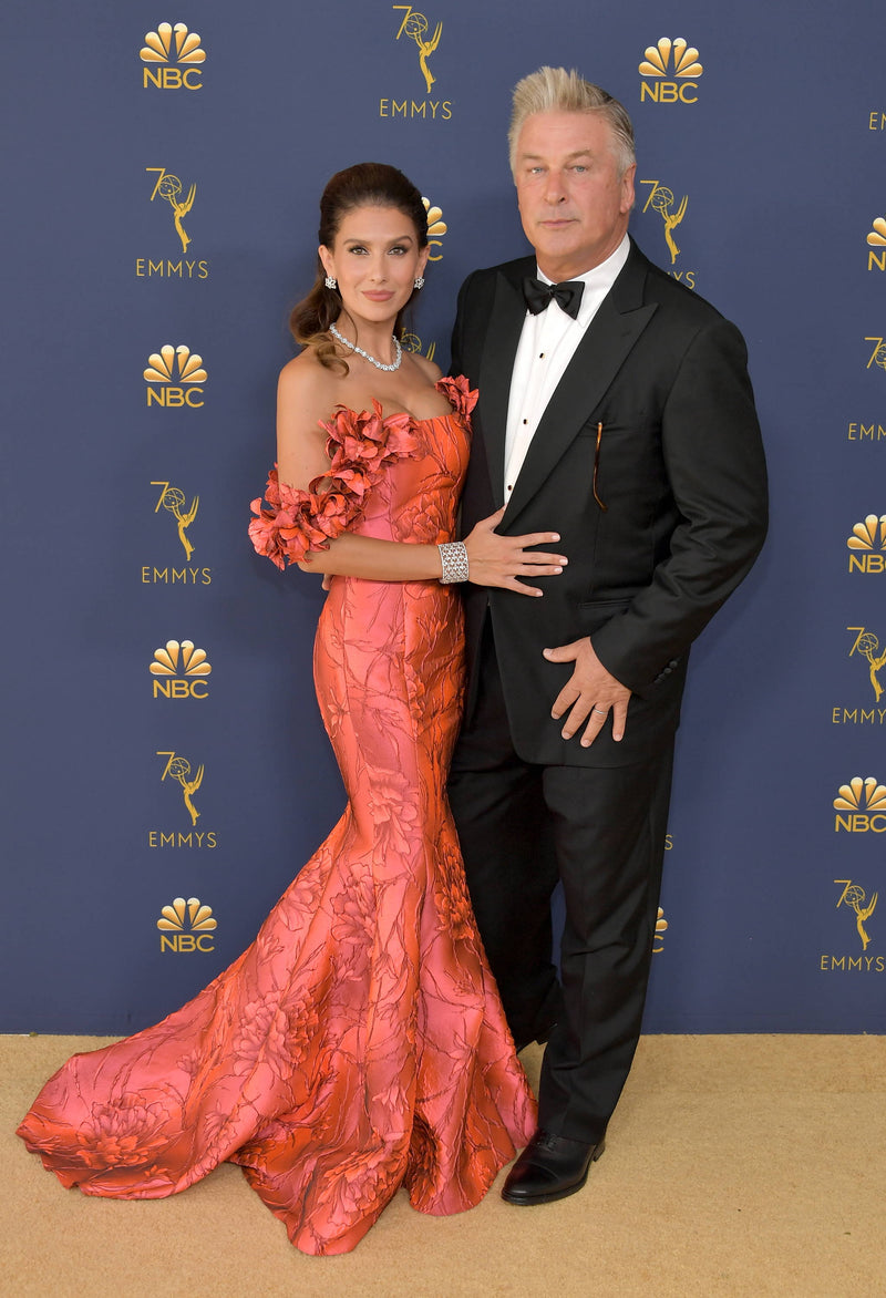 Ms. Baldwin, wife of Emmy nominee Alec Baldwin, is wearing a Badgley Mischka scarlet silk brocade gown with hand-made floral details